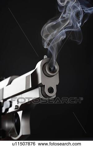 Smoking Handgun against black background View Large Photo Image Stock Photograph - Smoking Handgun against black background. Fotosearch
