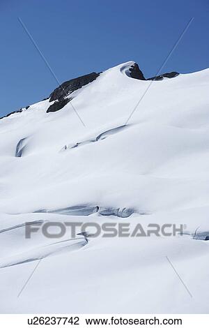 Stock Image - Snow filed on rocks. Fotosearch