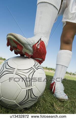 Soccer player (13-17) standing on ball low section View Large Photo Image Stock Image - Soccer player (13-17) standing on ball low section. Fotosearch