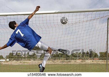 Stock Photograph - Soccer player scoring goal back view. Fotosearch