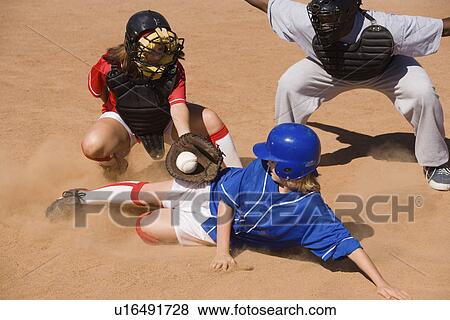 Softball player sliding into home plate View Large Photo Image Stock Photo - Softball player sliding into home plate. Fotosearch