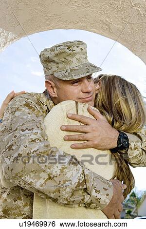 Stock Photograph - Soldier embracing wife outdoors. Fotosearch