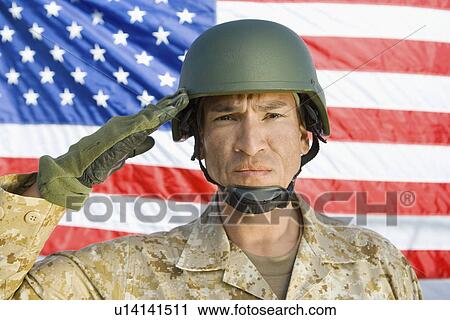Stock Image - Soldier saluting in front of United States flag (portrait). Fotosearch