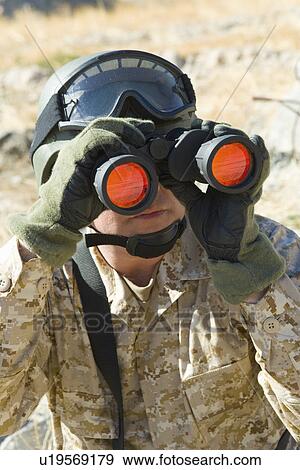 Stock Photo - Soldier using binoculars outdoors (close-up). Fotosearch
