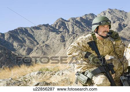 Stock Photo - Soldier using field phone in mountains. Fotosearch