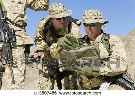 Stock Photograph - Soldiers consulting plans outdoors. Fotosearch