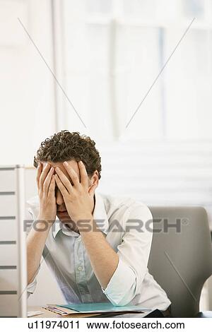 Stressed mid-adult male office worker sitting in cubicle head in hands View Large Photo Image Stock Image - Stressed mid-adult male office worker sitting in cubicle head in hands. Fotosearch