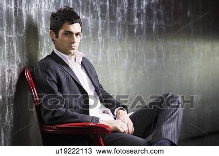Stylish Man sitting legs crossed in metal room side view View Large Photo Image Stock Image - Stylish Man sitting legs crossed in metal room side view. Fotosearch