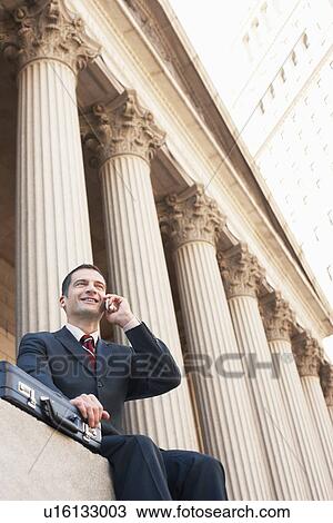 Succesful lawyer speaking on mobile phone outside courthouse View Large Photo Image Stock Image - Succesful lawyer speaking on mobile phone outside courthouse. Fotosearch