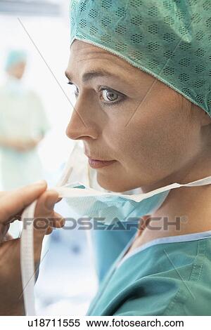 Stock Photography - Surgeon Putting on Face Mask in operating theatre close up. Fotosearch