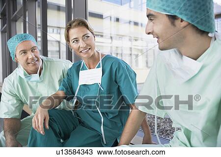 Stock Image - Surgeons having break Talking in Corridor. Fotosearch