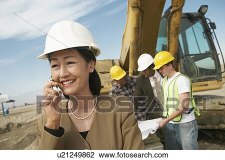 Stock Image - Surveyor Using Cell Phone. Fotosearch