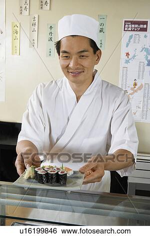 Sushi chef holding plate of sushi in restaurant View Large Photo Image Stock Photograph - Sushi chef holding plate of sushi in restaurant. Fotosearch