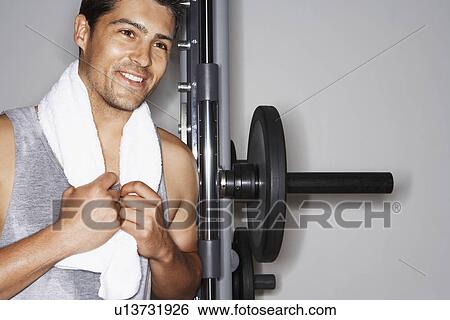 Sweaty man with towel by weight machine after workout View Large Photo Image Stock Photograph - Sweaty man with towel by weight machine after workout. Fotosearch