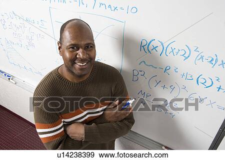 Stock Photo - Teacher writing maths equations on whiteboard portrait. Fotosearch