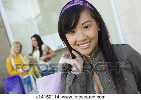 Picture - Teenage girl (16-17) smiling outdoors (portrait). Fotosearch