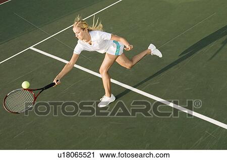 Tennis Player Reaching to hit tennis ball on tennis court View Large Photo Image Stock Image - Tennis Player Reaching to hit tennis ball on tennis court. Fotosearch