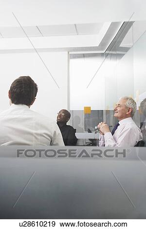 Stock Photo - Three businessmen sitting in office side view. Fotosearch