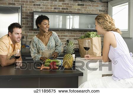 Three mid-adult friends having glass of wine in kitchen View Large Photo Image Stock Photography - Three mid-adult friends having glass of wine in kitchen. Fotosearch