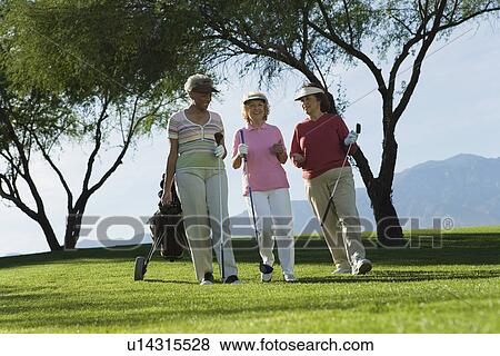 Three women walking on golf course View Large Photo Image Stock Photo - Three women walking on golf course. Fotosearch