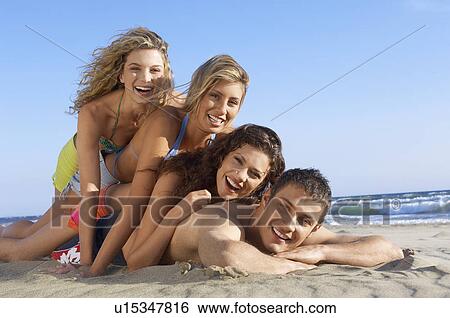 Three young women lying on man on beach portrait ground view View Large Photo Image Stock Photograph - Three young women lying on man on beach portrait ground view. Fotosearch