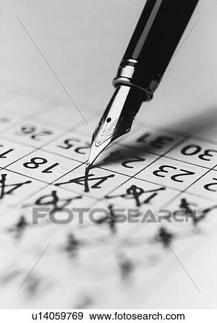 Stock Photo - Tip of fountain pen marking date in calendar (b&w) (close-up). Fotosearch