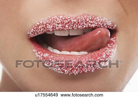 Stock Photo - Tongue licking lips covered in sugar. Fotosearch