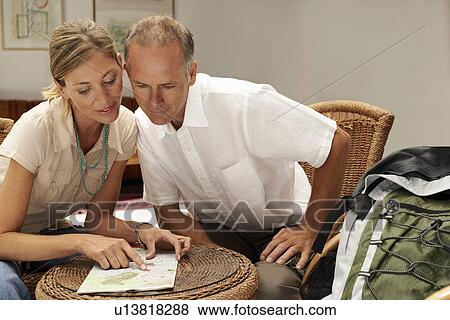 Stock Photo - Tourist Couple in Cafe looking at map front view. Fotosearch