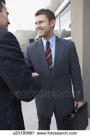 Two Businessmen Shaking Hands outside office View Large Photo Image Stock Photo - Two Businessmen Shaking Hands outside office. Fotosearch