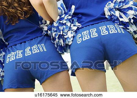 Two Cheerleaders holding pom-poms rear view (mid section) (close-up) View Large Photo Image Stock Photography - Two Cheerleaders holding pom-poms rear view (mid section) (close-up). Fotosearch