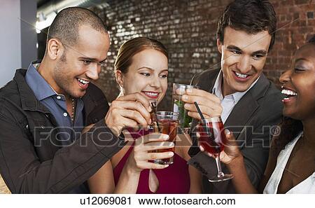 Two couples toasting standing in bar View Large Photo Image Stock Image - Two couples toasting standing in bar. Fotosearch