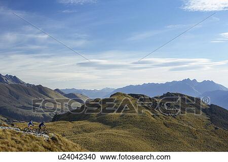 Two cyclists riding in hills back view View Large Photo Image Stock Image - Two cyclists riding in hills back view. Fotosearch
