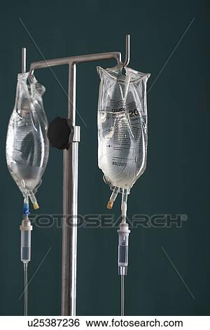 Two drip bags on stand against black background View Large Photo Image Stock Photograph - Two drip bags on stand against black background. Fotosearch