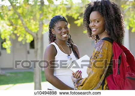 Stock Photo - Two female students smiling outdoors (portrait). Fotosearch