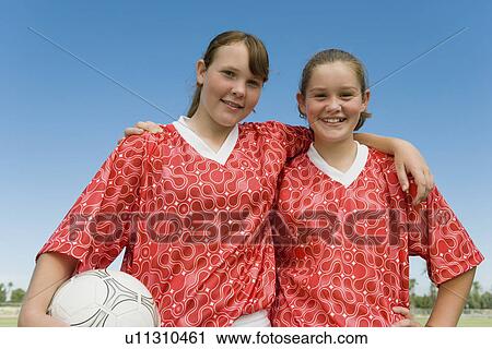 Stock Image - Two girls (13-17) dressed to play football portrait. Fotosearch