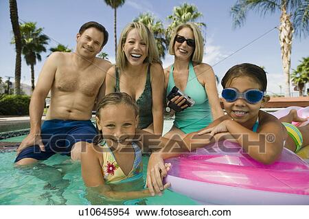 Two girls (7-9) with parents and grandmother in swimming pool portrait. View Large Photo Image Picture - Two girls (7-9) with parents and grandmother in swimming pool portrait.. Fotosearch