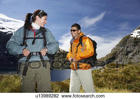 Two hikers smiling on mountain peak View Large Photo Image Stock Image - Two hikers smiling on mountain peak. Fotosearch