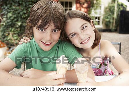 Two Kids Eating Ice Cream Cones at table in back yard portrait View Large Photo Image Stock Image - Two Kids Eating Ice Cream Cones at table in back yard portrait. Fotosearch