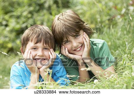 Two lying side by side in grass portrait View Large Photo Image Picture - Two lying side by side in grass portrait. Fotosearch