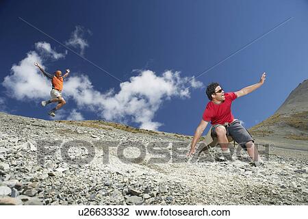 Stock Image - Two men sliding down screen field. Fotosearch
