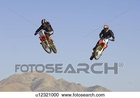 Two motocross Racers in mid-air View Large Photo Image Stock Image - Two motocross Racers in mid-air. Fotosearch