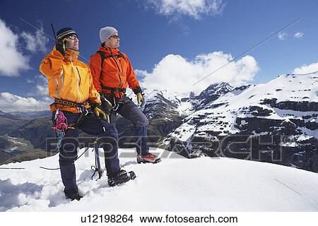 Picture - Two mountain climbers on snowy peak. Fotosearch