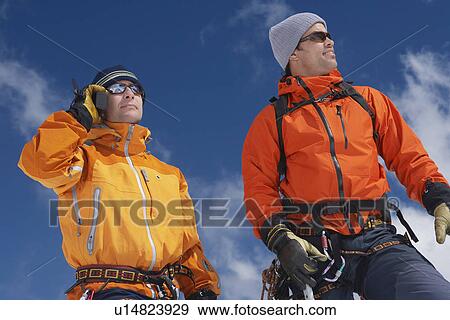 Two mountain climbers standing outdoors one using walkie-talkie View Large Photo Image Stock Photo - Two mountain climbers standing outdoors one using walkie-talkie. Fotosearch