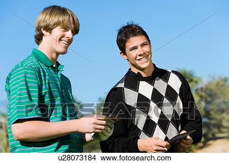 Picture - Two smiling golfers standing next to each other. Fotosearch