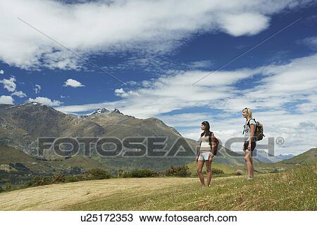 Two women hiking in hills near mountains View Large Photo Image Stock Image - Two women hiking in hills near mountains. Fotosearch