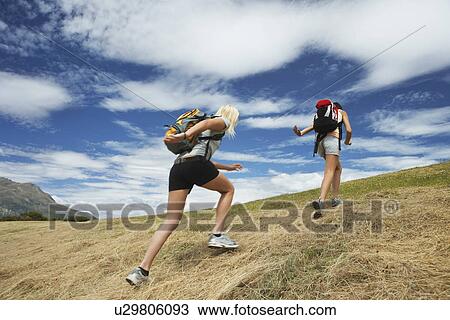 Two women running up hill back view View Large Photo Image Stock Image - Two women running up hill back view. Fotosearch