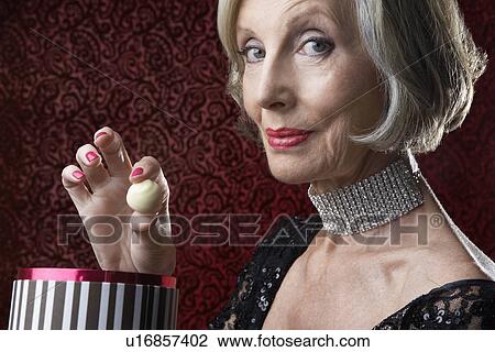 Stock Image - Wealthy Senior Woman with box of candy. Fotosearch