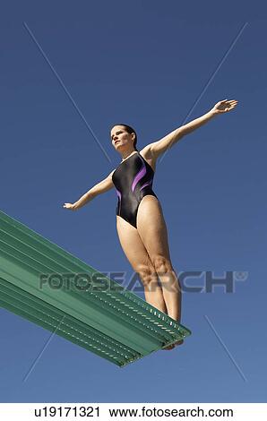 Woman about to dive backwards off a diving board View Large Photo Image Stock Image - Woman about to dive backwards off a diving board. Fotosearch