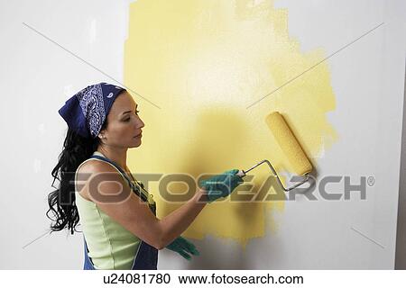 Woman applying yellow paint to interior wall View Large Photo Image Stock Image - Woman applying yellow paint to interior wall. Fotosearch