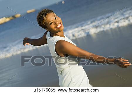 Stock Photography - Woman dancing on beach (portrait). Fotosearch